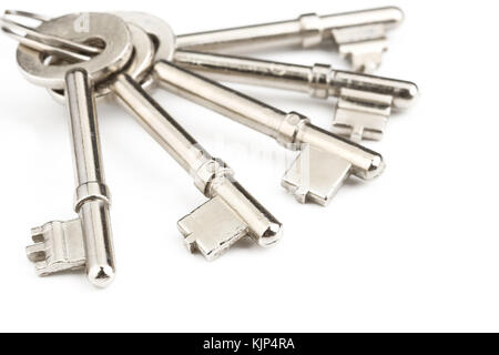 Old silver-color metal keys with key chain on white background Stock Photo