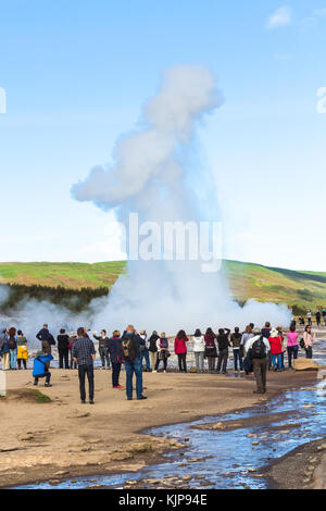 HAUKADALUR, ICELAND - SEPTEMBER 6, 2017: people photograph Strokkur geyser in Haukadalur area in september. Haukadalur geyser valley is one of the mos Stock Photo