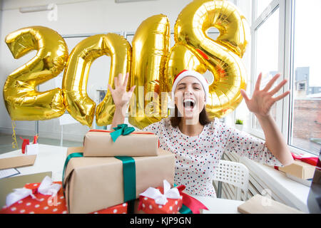 Ecstatic woman in Santa cap expressing her gladness of new 2018 year coming Stock Photo