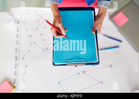 Secretary making financial notes on blue paper during presentation Stock Photo