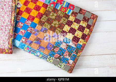 handmade, vintage, interior concept. nice cute little handmade blanket made from different colorful pieces using sewing technique patchwork wildly used in asia Stock Photo