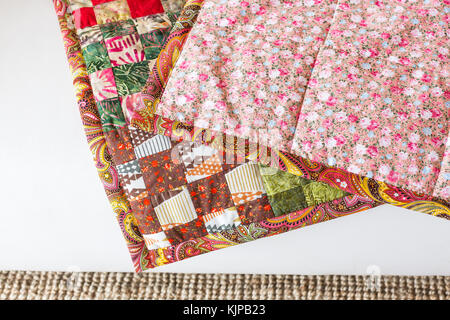 interior, hobby, homemade - multi-zoned scrappy covering stitched from a lot of old rags and ribbons which have patterns of abstract geometrical figures Stock Photo