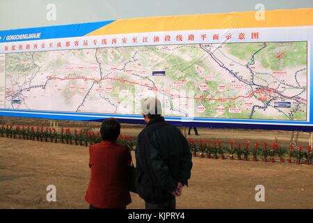 Beijing, China. 30th Nov, 2017. Residents look at the sketch map of Xi'an-Chengdu Passenger Railway in Xi'an, capital of northwest China's Shaanxi Province, Oct. 27, 2012. The 643-km line is China's first rail route to run through the Qinling Mountains. With a designed speed of 250 km per hour, it will slash the travel time between the two cities from the previous 16 hours. Credit: Xinhua/Alamy Live News Stock Photo