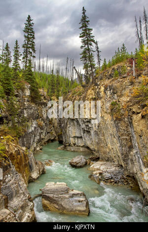 Beautiful Marble Canyon at Kootenay National Park in British Columbia, Canada. Vertical image of narrows, rock walls, sky, and flowing water. Stock Photo