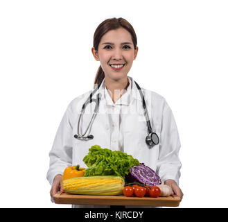 Portrait of beautiful asian young doctor holding the mix fresh vegetables in wooden plate on white background, closeup vegetable, Healthy food concept Stock Photo