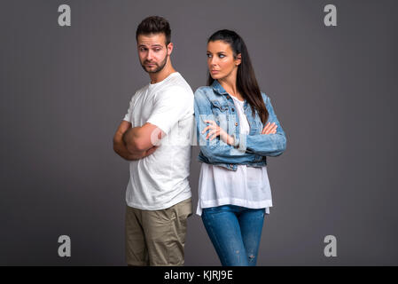 A beautiful young couple standing back to back and feeling upset to each other Stock Photo