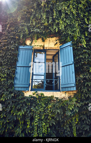 An open window with blue shutters in the summer Stock Photo