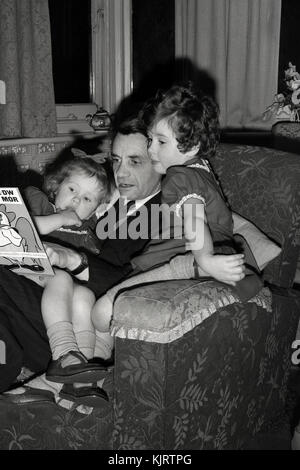 Father reading a bedtime story to his daughters Stock Photo