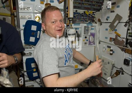 NASA STS-133 mission prime crew astronaut Eric Boe works in the middeck of the Space Shuttle Discovery while docked with the International Space Station March 4, 2011 in Earth orbit.  (photo by NASA Photo via Planetpix) Stock Photo