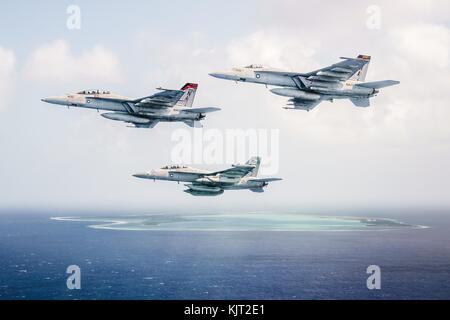 Two U.S. Navy F/A-18F Super Hornet jet fighter aircraft and a U.S. Navy EA-18G Growler electronic warfare attack aircraft fly in formation over Wake Island during a U.S. Navy Heritage event October 26, 2017 in the Pacific Ocean. (photo by Aaron B. Hicks via Planetpix) Stock Photo