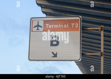 A weathered sign on a board showing the way to Terminal T2 B in Barcelona, Spain Stock Photo
