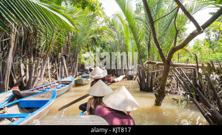 Boating on a dirty river with conical hats in the Mekong Delta, Vietnam Stock Photo