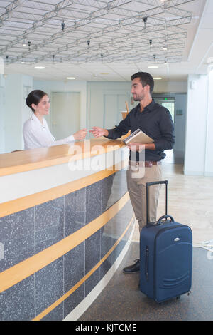 businessman does checking and pays receptionist by credit card pay Stock Photo