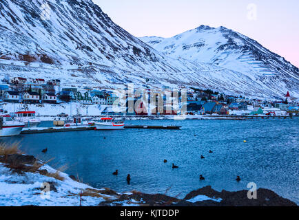 Siglufjordur harbor  at dawn in winter. Siglufjordur a small fishing town in a narrow fjord on the northern coast of Iceland. Stock Photo