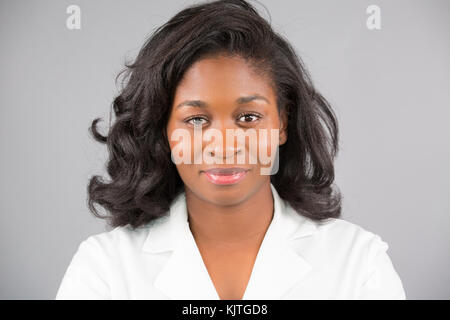 Closeup headshot portrait of friendly, smiling confident female doctor, healthcare professional with labcoat.  Isolated gray background. Stock Photo