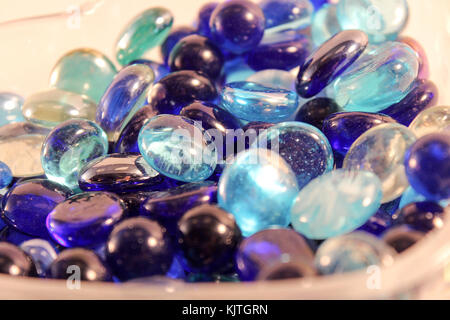 close up of glass blue and teal marbles in a glass container Stock Photo