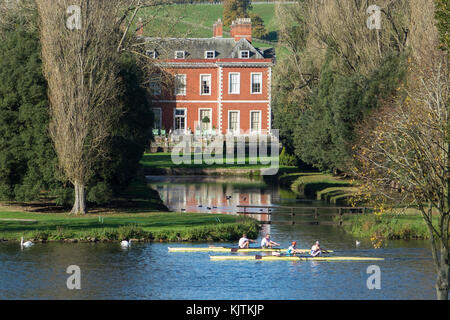 England, Buckinghamshire, Fawley court & rowers on river Thames Stock Photo
