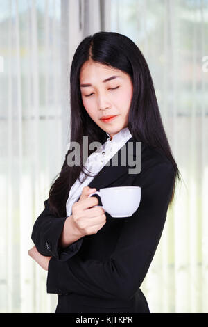 young business woman in suit with coffee or tea cup Stock Photo