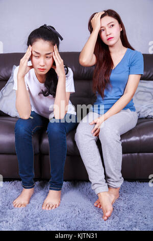 two worried woman on sofa in living room at home Stock Photo