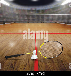 Sports arena with badminton racket and shuttlecock on wood flooring court. Deliberate focus on equipment and shallow depth of field on background. Flo Stock Photo