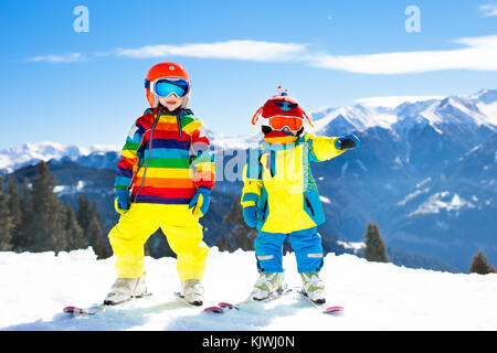 Child skiing in the mountains. Kid in ski school. Winter sport for kids. Family Christmas vacation in the Alps. Children learn downhill skiing. Alpine Stock Photo