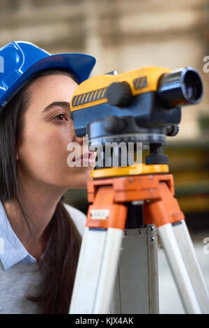 Serious surveyor engineer worker making measuring with theodolite equipment at construction site Stock Photo