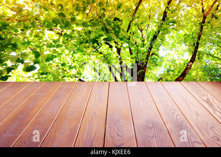 Wood floor with blurred trees of nature, park garden in summer background , Concept Is For montage product display,design key visual layout background Stock Photo