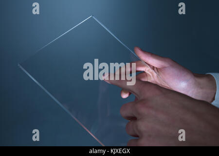 Male hands holding blank futuristic transparent digital tablet pc computer with copy space Stock Photo