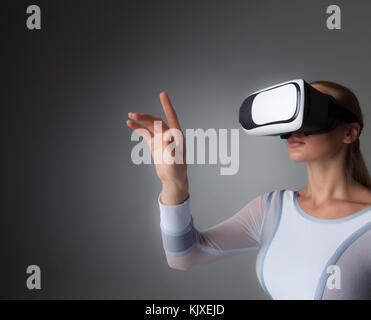 Young woman in white futuristic clothes with vr headset Stock Photo