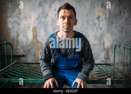 Madman in uniform mouth sealed with plaster, psycho patient. Mentally ill people concept, crazy human Stock Photo