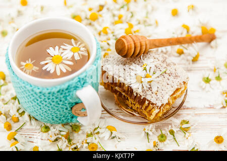 Honeycomb and chamomile tea on white Stock Photo