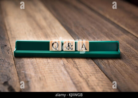 Queations and Answers Q&A concept. Q&A letter on alphabet tiles on wooden table Stock Photo