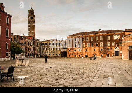 A lone unknown pedestrian crosses a deserted Campo San Anzolo in the early morning in Venice on September 13, 2017. Stock Photo