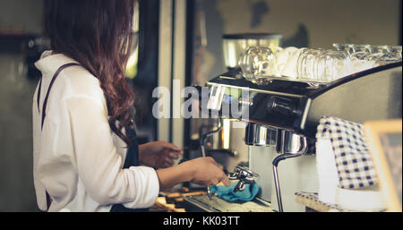 Asian women Barista smiling and using coffee machine in coffee shop counter - Working woman small business owner food and drink cafe concept Stock Photo