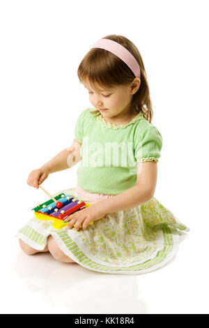 Girl playing on xylophone isolated on white Stock Photo