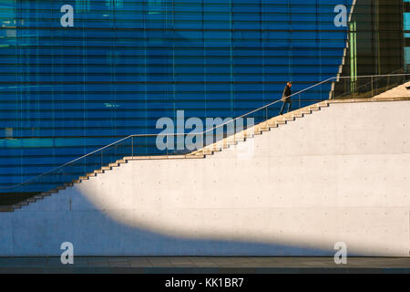Man alone city, view on a late spring afternoon of a solitary man climbing the staircase alongside the Maria-Elisabeth-Luders Haus in Berlin, Germany. Stock Photo