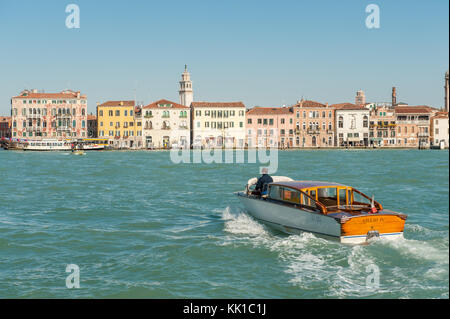 Classic Venetian motorboat crossing Giudecca Canal and approaching Doroduro Stock Photo