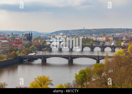 Remarkable view of Prague bridges over Vltava river with historic embankment. Daytime, spring season, green park at the foreground Stock Photo