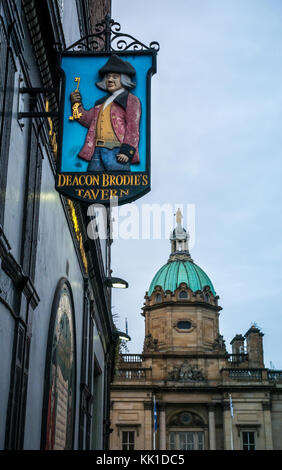 Old pub sign, Deacon Brodies Tavern, Royal Mile, Edinburgh, Scotland, UK, with copper dome of Scotland headquarters on The Mound Stock Photo