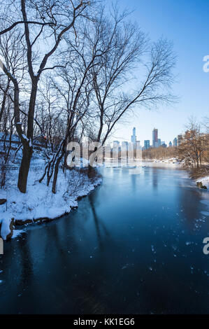 Wintry view of Central Park from the frozen lake with the urban skyline of the Upper West Side in Manhattan, New York City Stock Photo