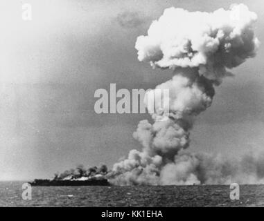 Loss of USS Princeton (CVL-23), 24 October 1944 - Princeton burning soon after she was hit by a Japanese bomb while operating off the Philippines on 24 October 1944. This view, taken from USS South Dakota (BB-57) at about 1001 hrs., shows the large smoke column passing aft following a heavy explosion in the carrier's hangar deck Stock Photo