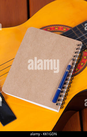 Diary and a used pencil on classical guitar background Stock Photo