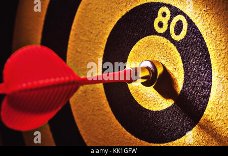 Closeup view on toy darts and yellow-black target. Stock Photo