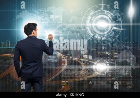 Businessman writing the modern virtual screen over the Trading graph on the cityscape at night and world map background, Business financial and techno Stock Photo