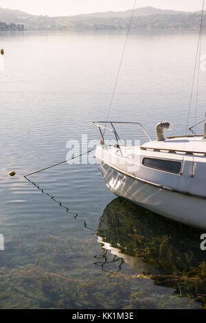 White sail boat dock at wooden floating tourist pier in sunny summer morning Stock Photo