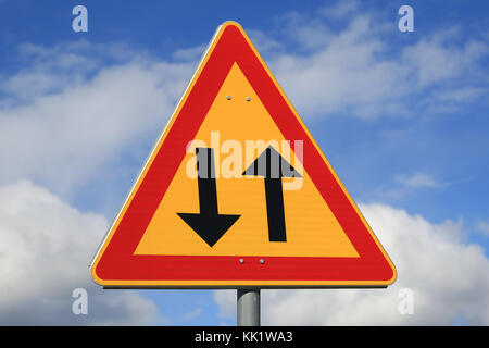 Sign two way traffic against blue sky with some clouds. Stock Photo