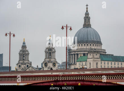 Zoom view of people walking on Blackfriars Bridge, ornate old fashioned lamp posts and St Pauls Cathedral, River Thames, London, England, UK Stock Photo