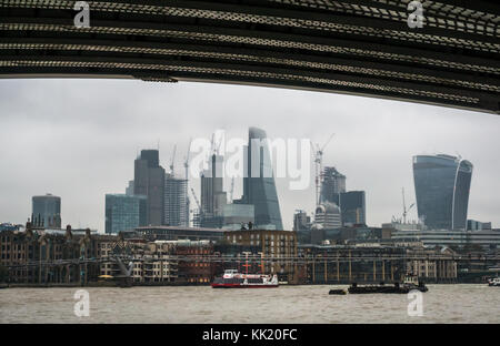 View of City of London skyscrapers from under Blackfriars railway Bridge, River Thames, London, England, UK, on misty dull day with grey sky Stock Photo