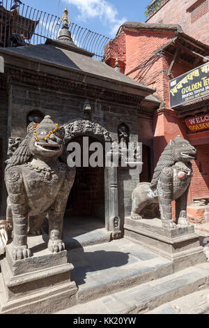 Lion statues in front of the entrance of the Golden Temple (Kwa Bahal) on Durbar square. Patan, Kathmandu, Nepal. Stock Photo