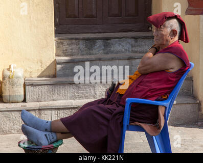 Tired  Buddhist monk resting, Kathmandu's Monkey Temple. Nepal Stock Photo